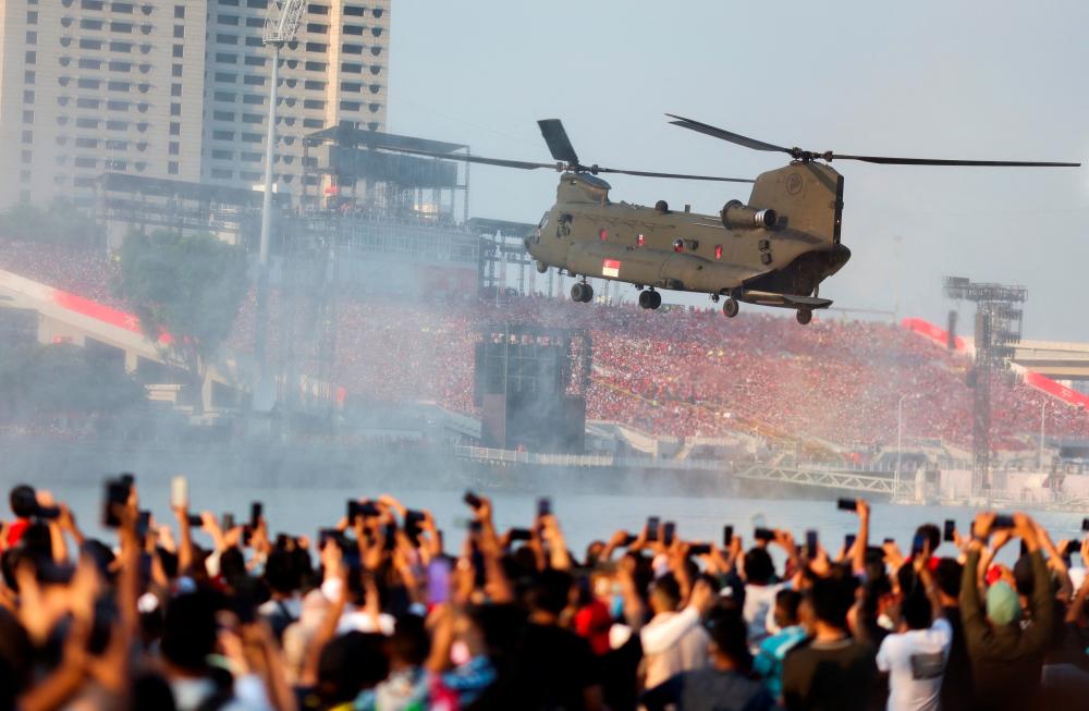 Helikopter CH-47 Chinook Tentera Udara Singapura (RSAF) membuat persembahan di atas Marina Bay semasa sambutan Hari Kebangsaan di Singapura 9 Ogos 2022. REUTERSpix
