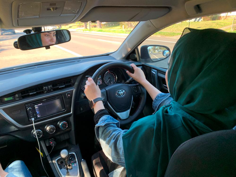 Newly-arrived Afghan refugee Sahar Azizi drives a vehicle during her second driving lesson in Sydney, Australia August 2, 2022. - REUTERSPIX