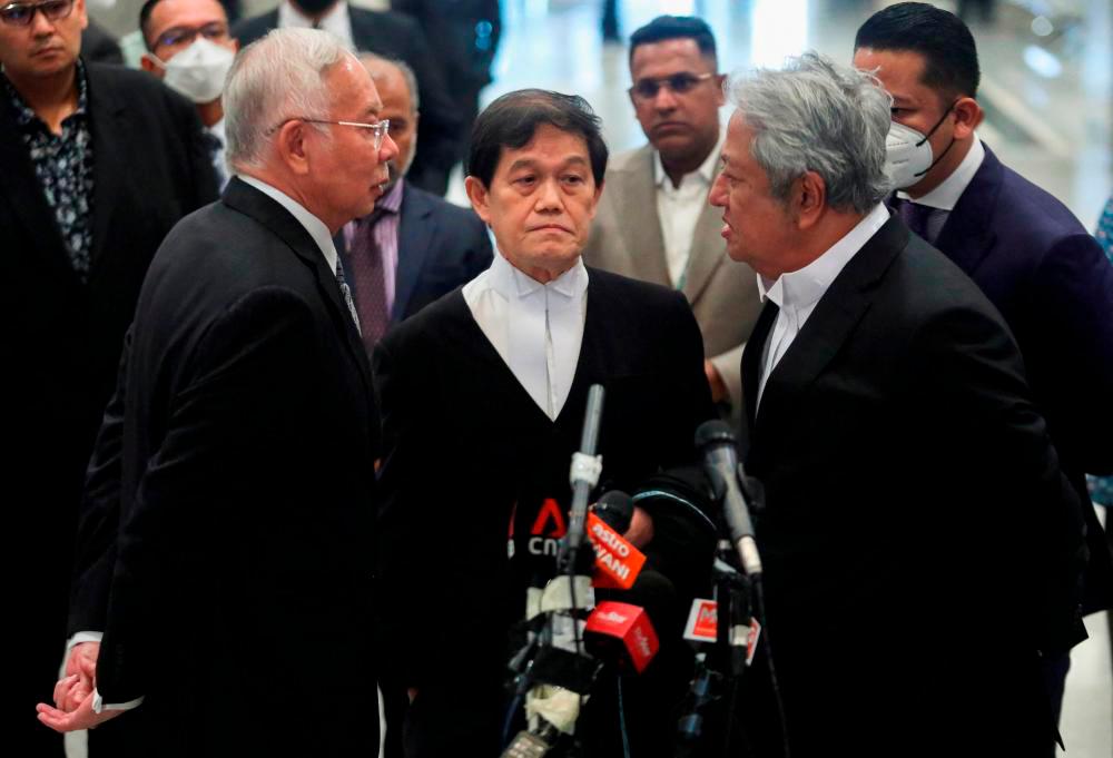 Bekas Perdana Menteri Malaysia Najib Razak bercakap dengan peguamnya Hisyam Teh Poh Teik (tengah) dan Zaid Ibrahim semasa sidang akhbar di Mahkamah Persekutuan di Putrajaya, Malaysia 16 Ogos 2022. REUTERSPIX