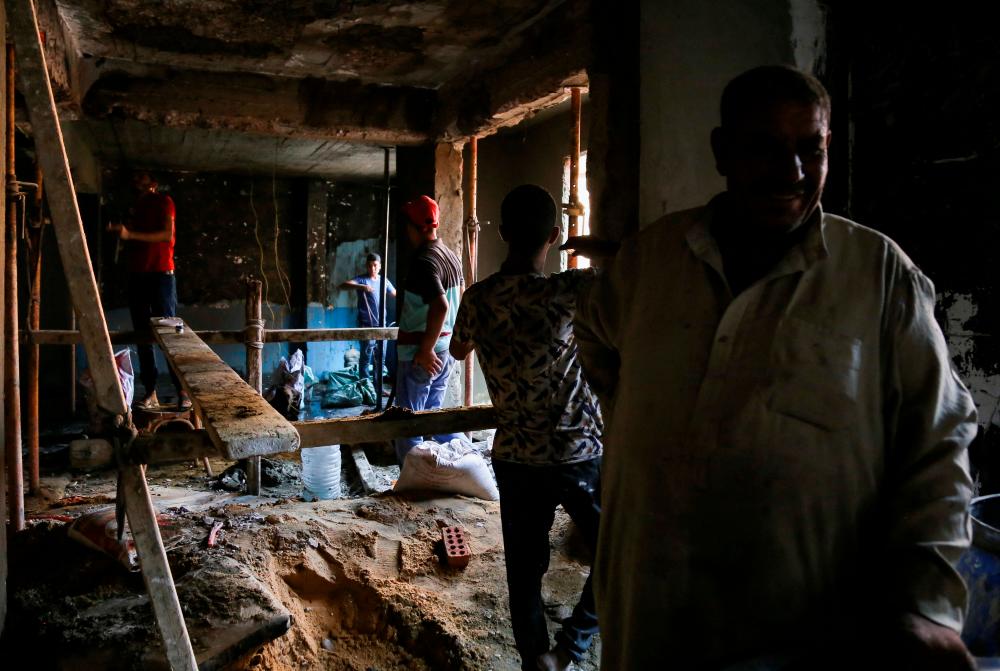 Egyptian employees start renovation works and picking up debris at burned Abu Sifin church after a deadly electrical fire broke out during Sunday Mass, in the Imbaba district of Giza, Egypt August 15, 2022. REUTERSpix
