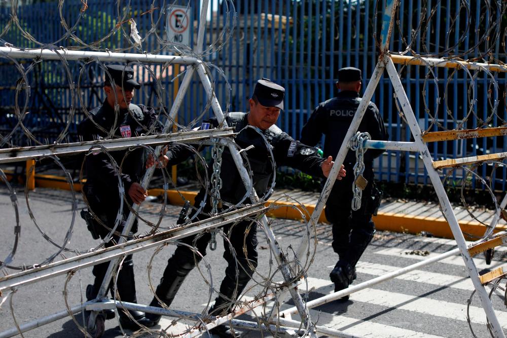 Police officers secure barricades prior to a protest to demand the release of people detained during the government's state of emergency to curb down gang violence, in San Salvador, El Salvador August 16, 2022. - REUTERSPIX