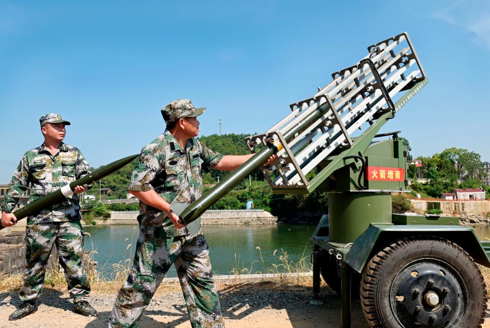 Militia members load an equipment for cloud-seeding operations as part of the drought relief measures amid a heatwave warning in Dongkou county of Shaoyang, Hunan province, China August 17, 2022. REUTERSPIX