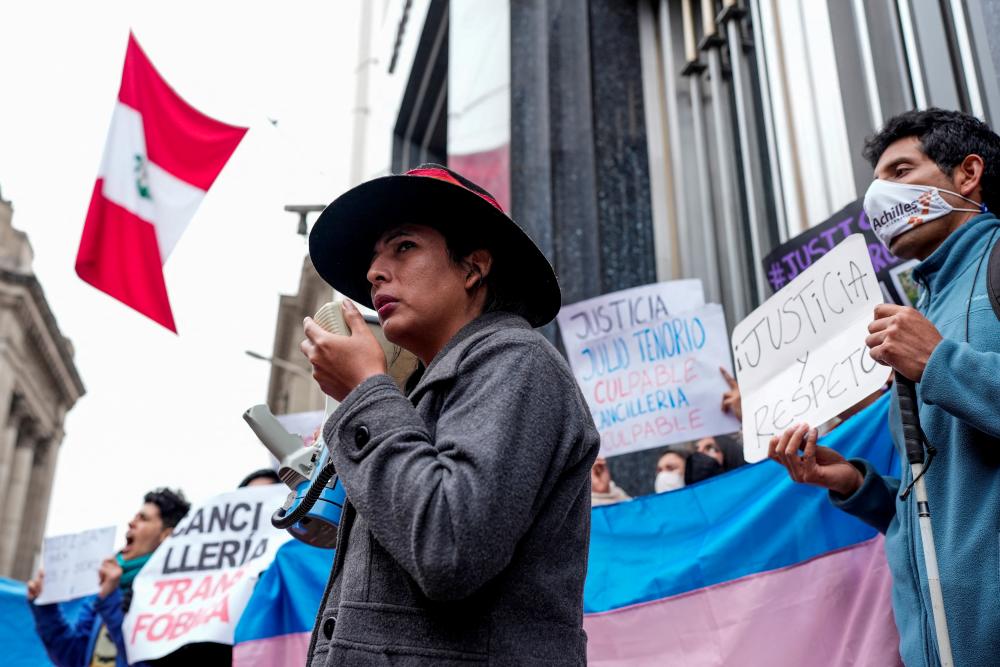 A demonstrator uses a megaphone during a protest to demand justice for Rodrigo Ventosilla, a Peruvian graduate student at Harvard and activist for transgender rights who died on the island of Bali days after being detained for alleged cannabis possession, along with his husband, outside Peru's foreign ministry building, in Lima, Peru August 26, 2022. - REUTERSPIX