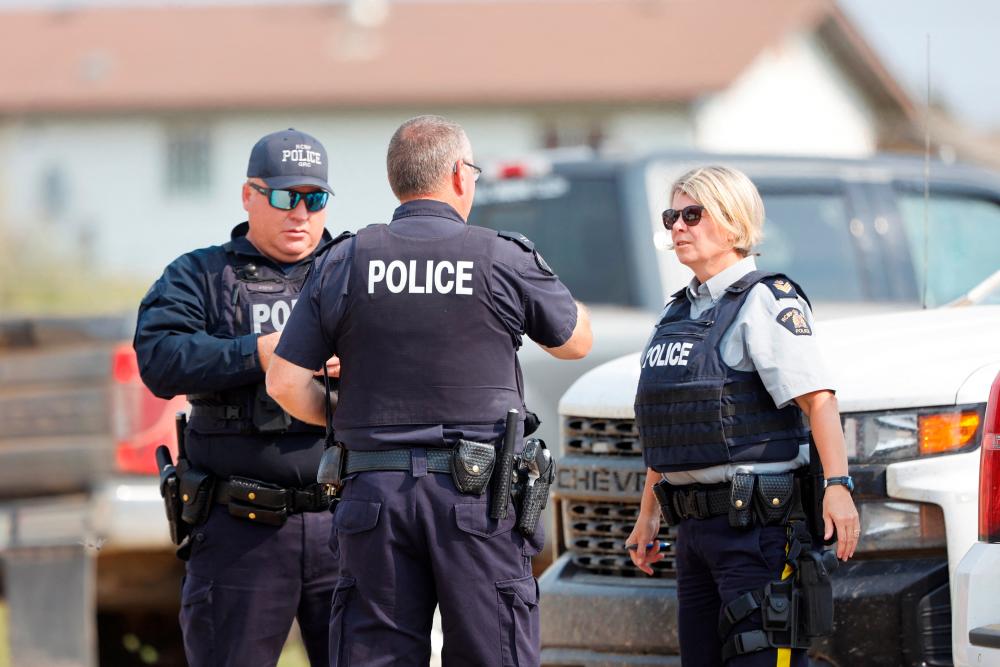 Royal Canadian Mounted Police (RCMP) officers at James Smith Cree Nation talk after multiple people were killed and injured in a stabbing spree on the reserve and nearby town of Weldon, Saskatchewan, Canada/Reuters