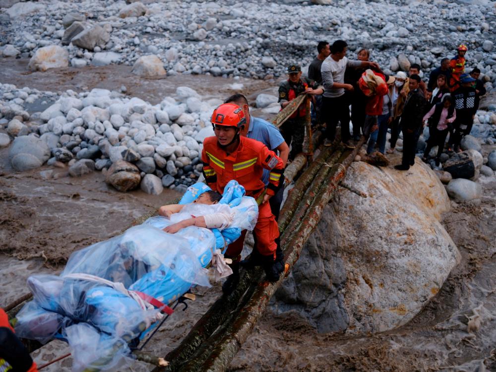 Rescue workers carry an injured victim on a stretcher following a 6.8-magnitude earthquake in Qinggangping village, Luding county, Ganzi Tibetan Autonomous Prefecture, Sichuan province, China/REUTERSPix