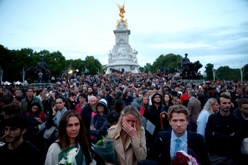 People react outside the Buckingham Palace, after Queen Elizabeth, Britain’s longest-reigning monarch and the nation’s figurehead for seven decades, died aged 96, according to Buckingham Palace, in London/REUTERSPix