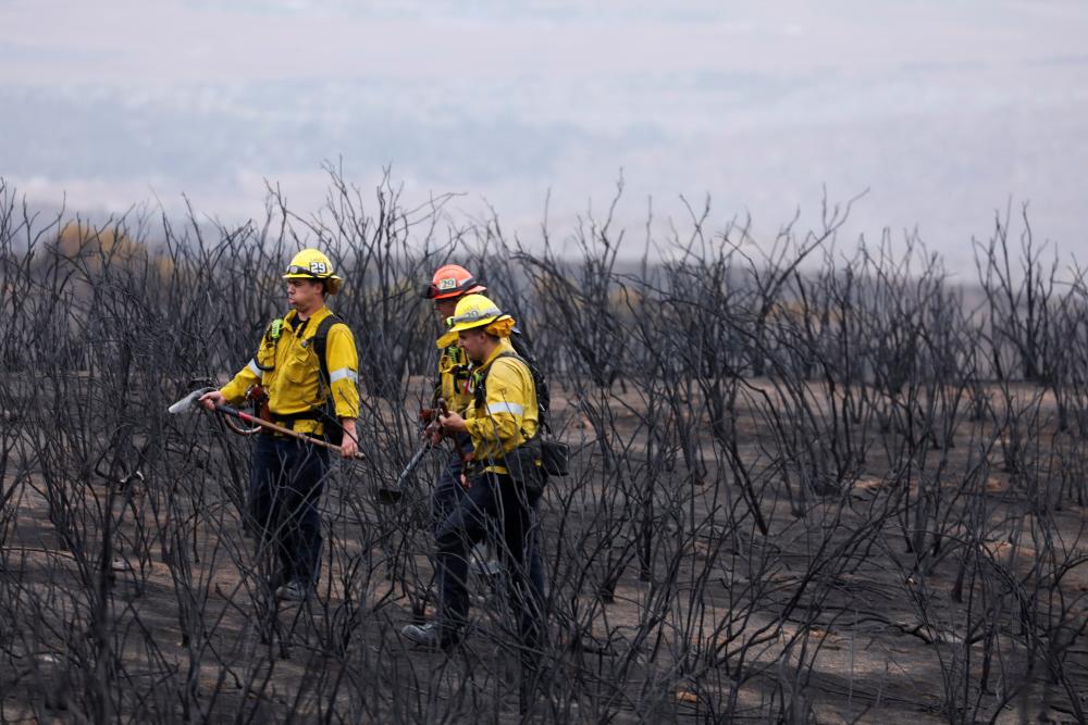 Firefighters look for hotspots in the black as the Fairview Fire smoulders near Hemet, California, U.S., September 9, 2022. - REUTERSPIX