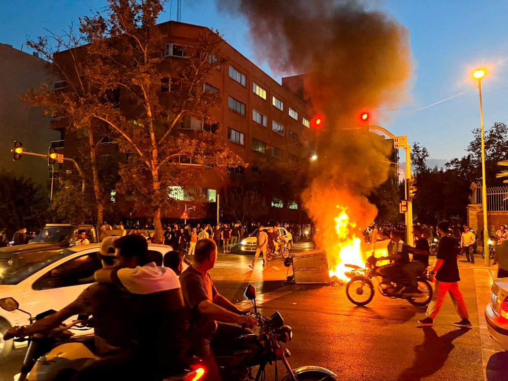 FILE PHOTO: A police motorcycle burns during a protest over the death of Mahsa Amini, a woman who died after being arrested by the Islamic republic’s “morality police”, in Tehran, Iran September 19, 2022. REUTERSPIX