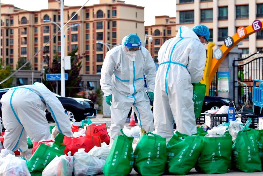 Volunteers in protective suits sort supplies for residents outside a residential compound under lockdown, following cases of the coronavirus disease (Covid-19) in Lhasa, Tibet Autonomous Region, China September 29, 2022. REUTERSPIX