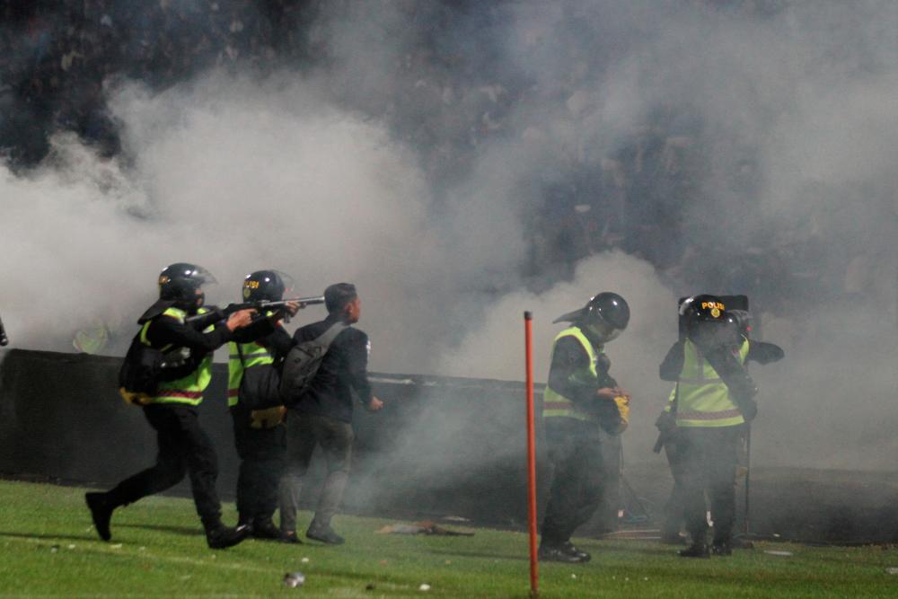 A riot police officer fires tear gas after the football match between Arema vs Persebaya at Kanjuruhan Stadium, Malang, East Java province, Indonesia, October 1, 2022 - REUTERSPIX