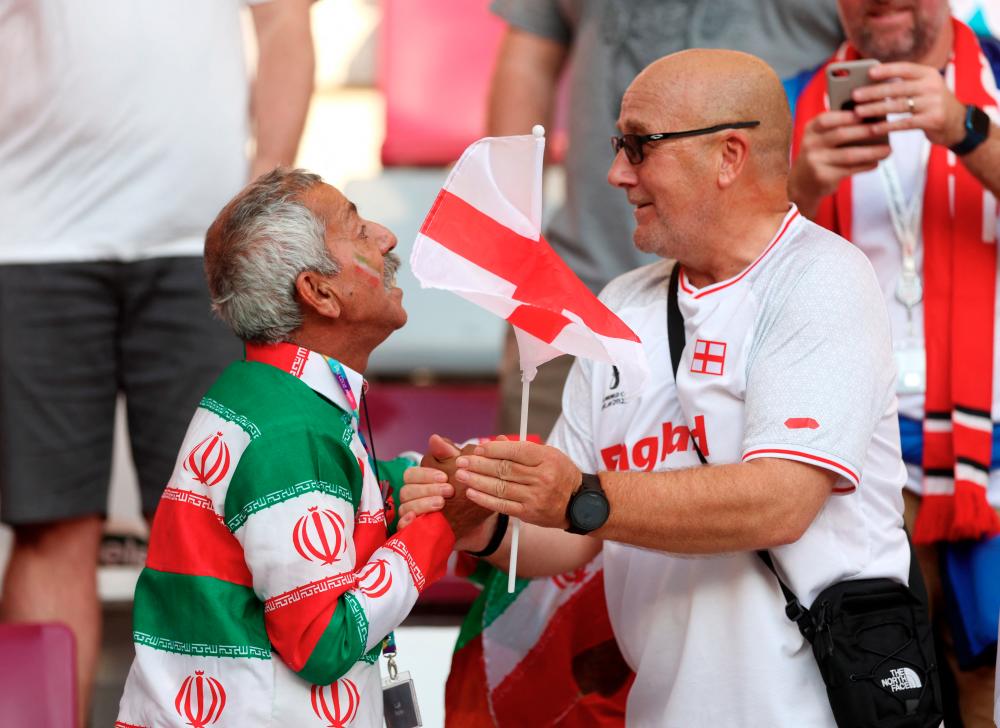 $!England and Iran fans greeting each other inside the stadium before the match. – REUTERSPIX