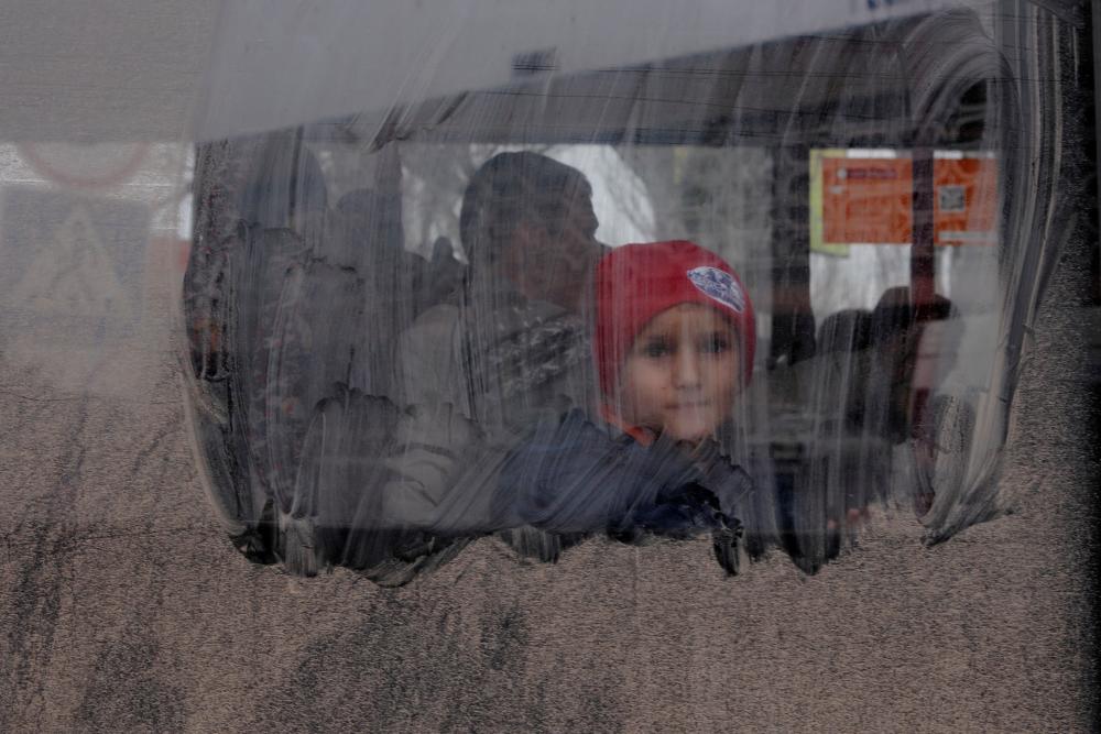 A boy looks out from an evacuation bus, after Russia’s military retreat from Kherson, at the central bus station in Kherson, Ukraine November 24, 2022. REUTERSPIX