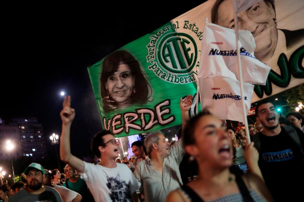 Supporters of Argentine Vice President Cristina Fernandez de Kirchner react next to a banner with her image and the one of late former president Nestor Kirchner after a federal court found her guilty in a corruption case, in Buenos Aires, Argentina December 6, 2022. REUTERSPIX