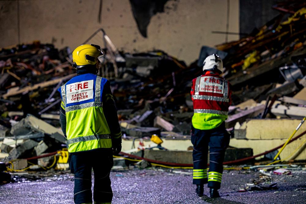 Search crew work at a blast site at a block of flats in Saint Helier, on the island of Jersey, Britain December 10, 2022 in this picture obtained from social media. - AFPPIX