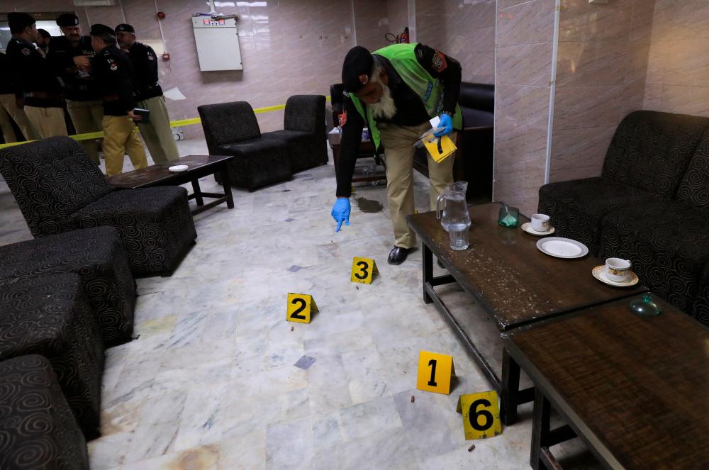 A police officer surveys the crime scene after, according to police, a gunman killed Abdul Latif Afridi, lawyer and former president of Pakistan’s Supreme Court Bar Association, in Peshawar, Pakistan January 16, 2023/REUTERSPix