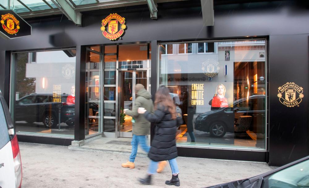 People walk past a lounge of British soccer club Manchester United during the World Economic Forum (WEF) 2023 in the Alpine resort of Davos, Switzerland, January 15, 2023. REUTERSPIX