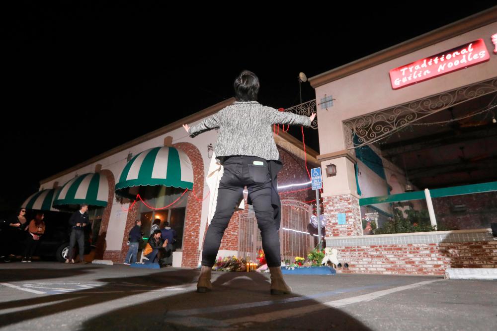 People stand outside the entrance of the Star Ballroom Dance Studio after a mass shooting during Chinese Lunar New Year celebrations in Monterey Park, California, U.S. January 23, 2023. REUTERSPIX