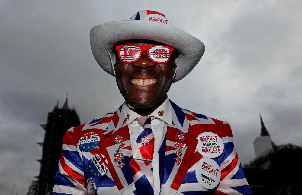 A pro-Brexit supporter smiles as he poses on Parliament Square, on Brexit day, in London, Britain January 31, 2020. REUTERSPIX