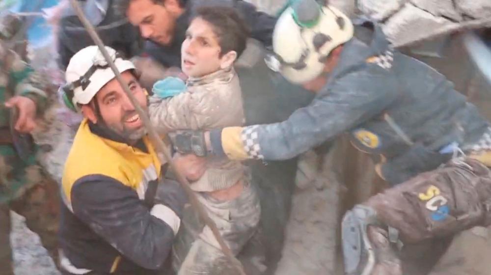 The White Helmet volunteers rescue a child from under rubble, in the aftermath of a deadly earthquake, in Jandaris, Syria February 8, 2023, in this still image obtained from a social media video/The White Helmets/via REUTERS