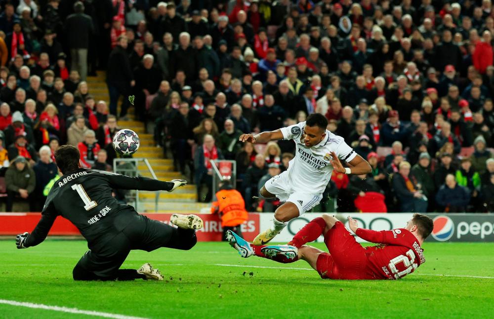 Football - Champions League - Round of 16 First Leg - Liverpool v Real Madrid - Anfield, Liverpool, Britain - February 21, 2023 Real Madrid’s Rodrygo in action with Liverpool’s Alisson and Andrew Robertson REUTERSpix