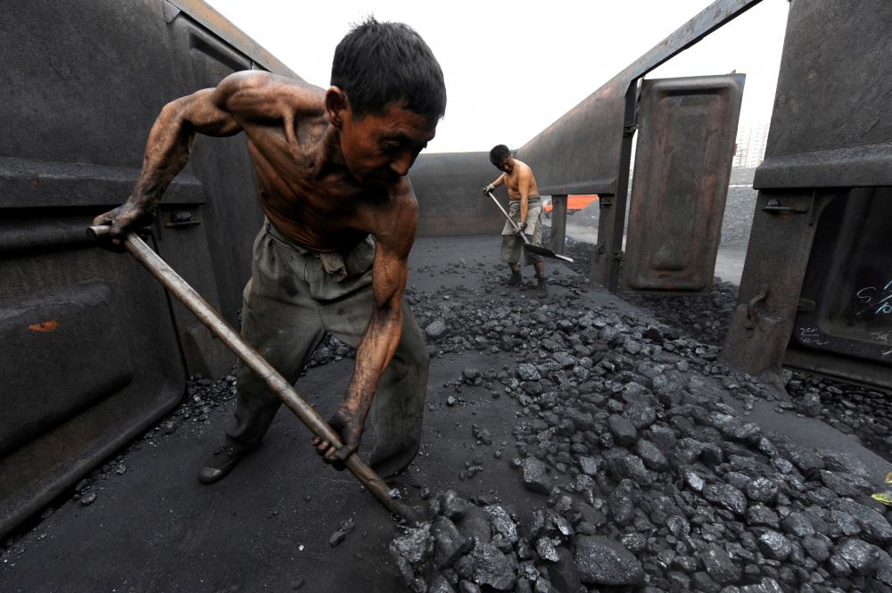 Workers unload coal at a storage site along a railway station in Hefei, Anhui province October 27, 2009. REUTERSPIX