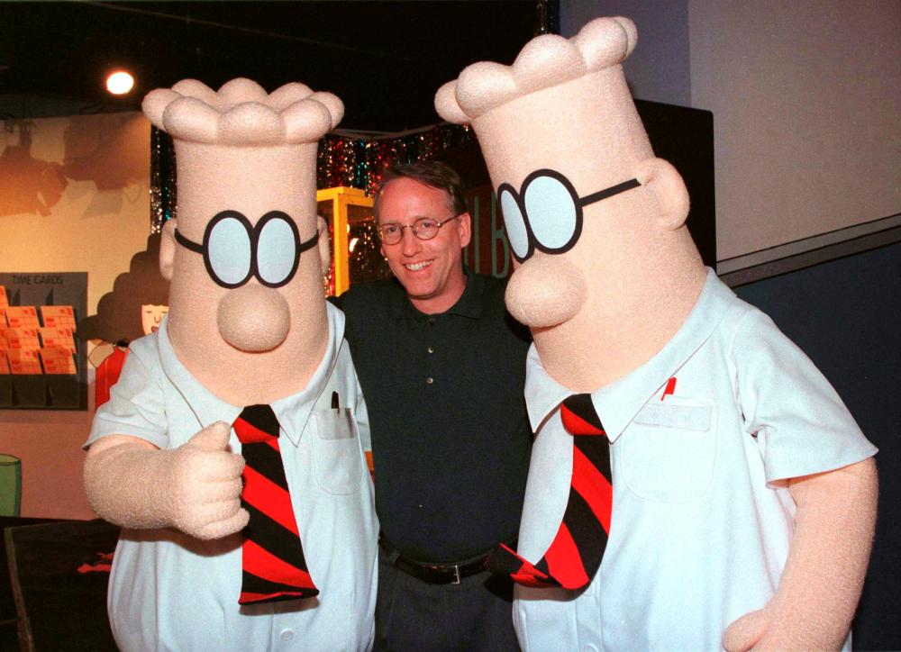 Scott Adams, the creator of “Dilbert”, the cartoon character that lampoons the absurdities of corporate life, poses with two “Dilbert” characters at a party January 8, 1999 in Pasadena, Calif. REUTERSPIX
