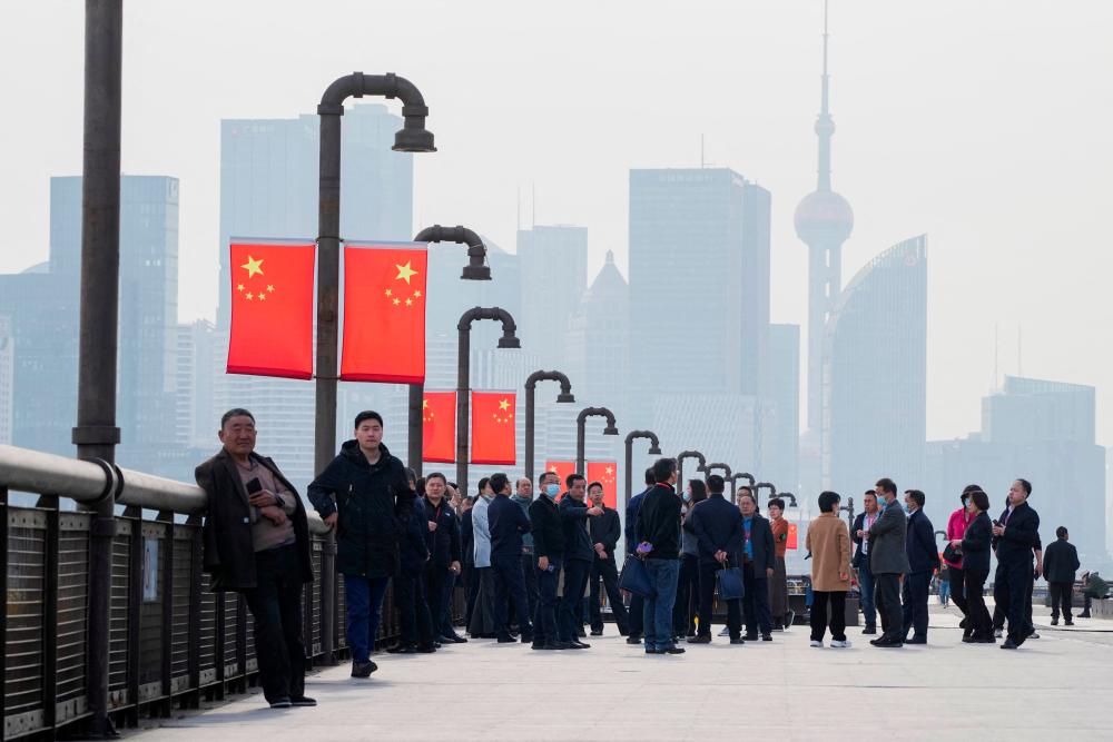 People visit a riverside in front of the Lujiazui financial district, during the National People’s Congress (NPC) in Shanghai, China, March 7, 2023. REUTERSPIX