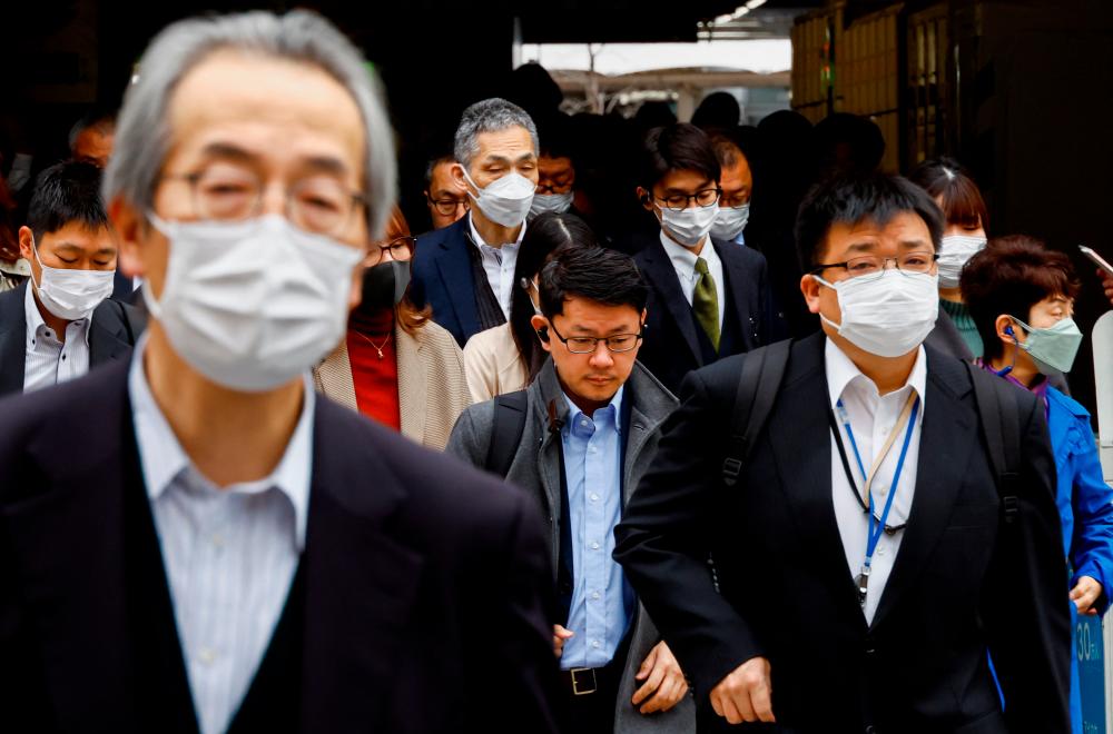 Commuters make their way on the first day of the Japanese government’s relaxation of official guidance on masks as it emerges from the Covid-19 pandemic, in Tokyo, Japan March 13, 2023. REUTERSPIX