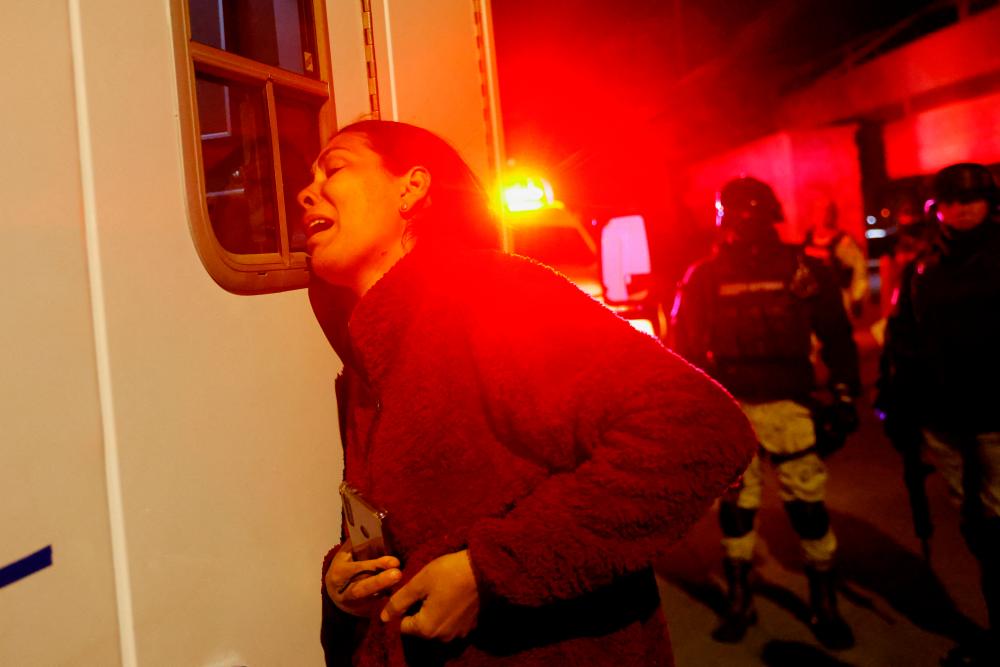 Viangly, a Venezuelan migrant, reacts outside an ambulance for her injured husband Eduard Caraballo while Mexican authorities and firefighters remove injured migrants, mostly Venezuelans, from inside the National Migration Institute (INM) building during a fire, in Ciudad Juarez, Mexico March 27, 2023. REUTERSPIX