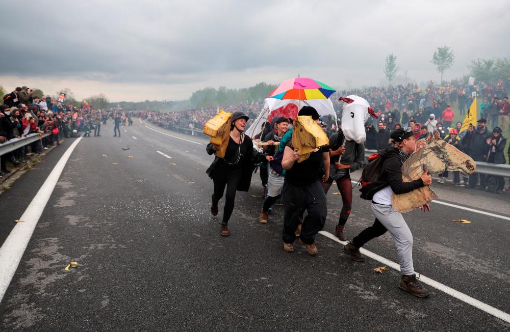 Activists gather to protest against a highway project between Toulouse and Castres, which worry environmental activists to see hundreds of hectares of agricultural land and trees disappear, near the village of Saix, France, April 22, 2023/REUTERSPix