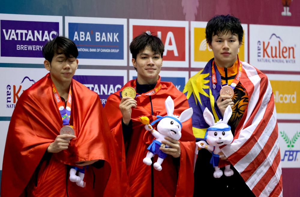 Vietnam’s Hung Nguyen Tran celebrates winning gold medal alongside silver medalist Vietnam’s Quang Thuan Nguyen and bronze medalist Malaysia’s Tan Khai Xin in men’s individual medley 400m/REUTERSPix