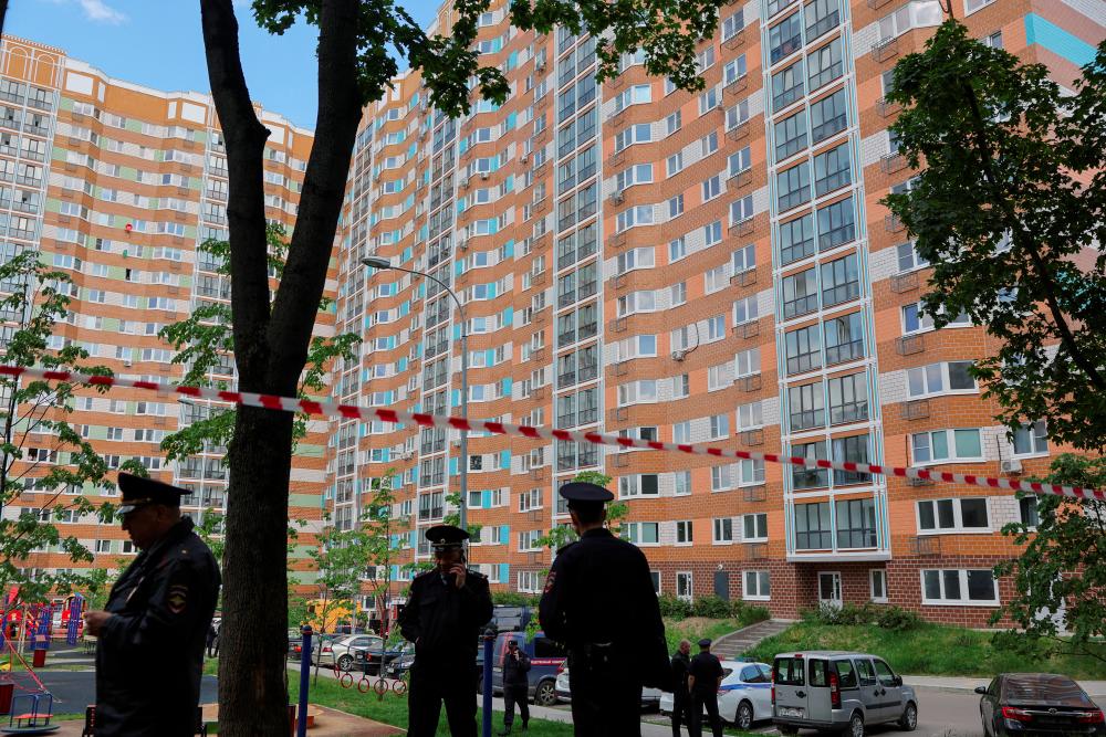 Russian law enforcement officers stand guard near a damaged multi-storey apartment block following a reported drone attack in Moscow, Russia, May 30, 2023. - REUTERSPIX