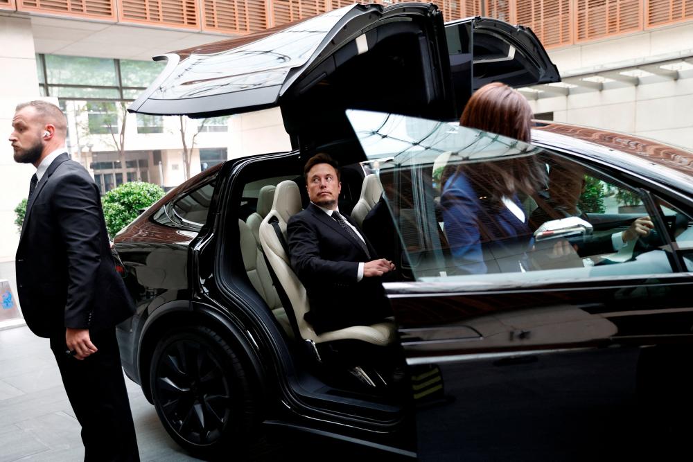 Tesla Chief Executive Officer Elon Musk gets in a Tesla car as he leaves a hotel in Beijing, China May 31, 2023/REUTERSPix