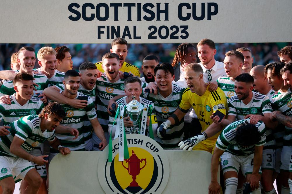 Celtic’s Callum McGregor celebrates with the trophy and teammates after winning the Scottish Cup/REUTERSPix