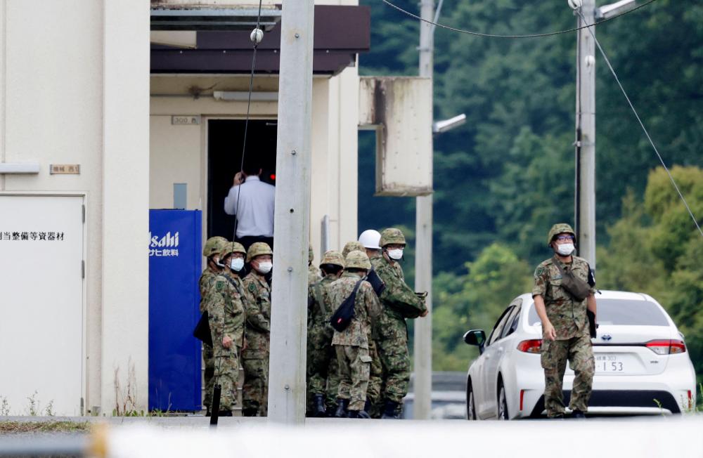 Members of the Japanese Self-Defence Force (SDF) are seen around the shooting range, in which a teenage member of SDF was arrested on suspicion of attempted murder after a shooting incident, in Gifu, Gifu Prefecture, Japan June 14, 2023. REUTERSPIX