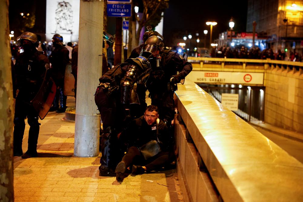 Police hold down a young person during the fifth night of protests following the death of Nahel, a 17-year-old teenager killed by a French police officer in Nanterre during a traffic stop, in the Champs Elysees area, in Paris, France, July 2, 2023. - REUTERSPIX