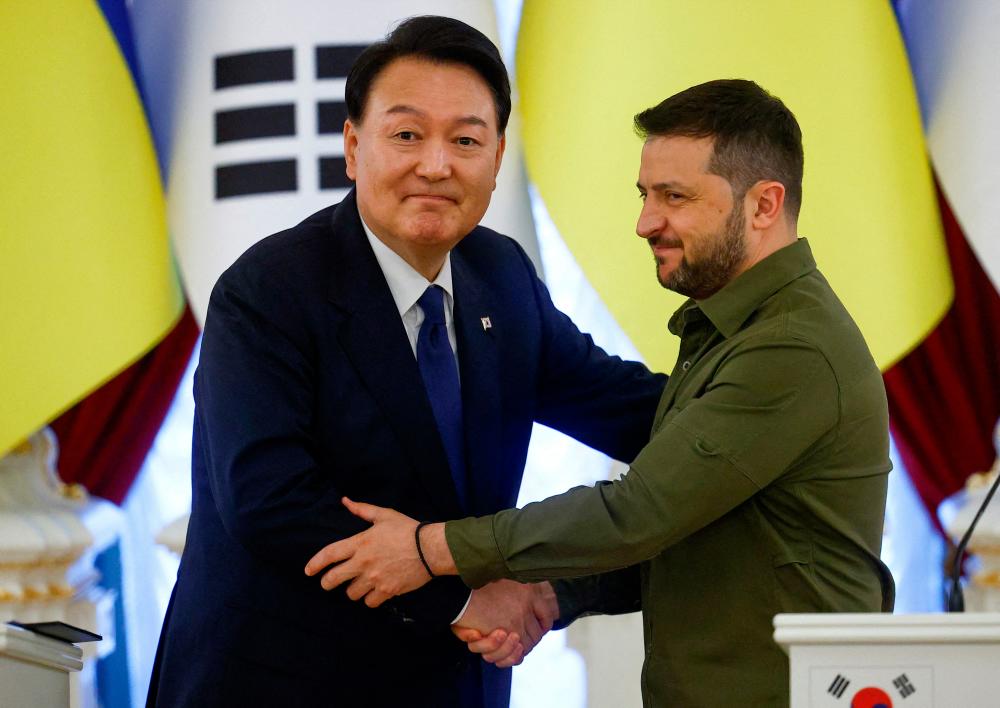 Ukraine’s President Volodymyr Zelenskiy and South Korean President Yoon Suk Yeol shake hands after a joint statement, amid Russia’s attack on Ukraine, in Kyiv, Ukraine July 15, 2023. REUTERS/PIX