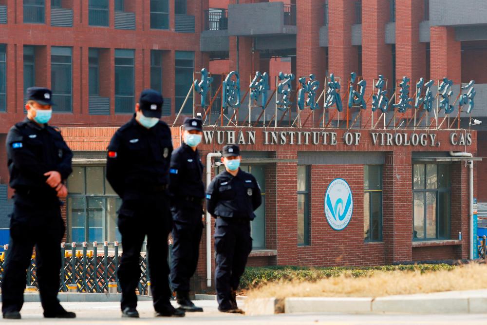 Security personnel keep watch outside Wuhan Institute of Virology during the visit by the World Health Organization (WHO) team tasked with investigating the origins of the coronavirus disease (Covid-19), in Wuhan, Hubei province, China February 3, 2021. REUTERSPIX