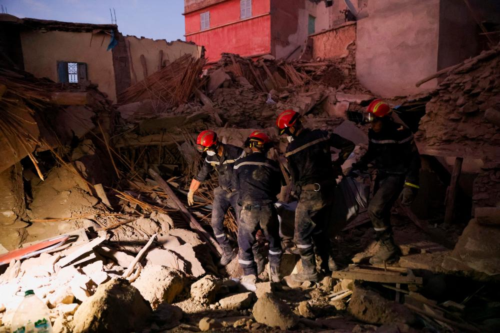 Emergency workers carry a dead body, in the aftermath of a deadly earthquake, in Amizmiz, Morocco, September 10, 2023. REUTERSPIX