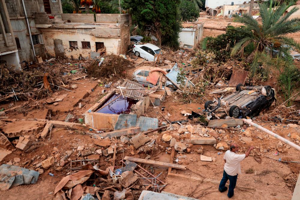 A flood survivor reacts as he walks past damaged cars and rubble, in the aftermath of the deadly storm that hit Libya, in Derna, Libya September 19, 2023/AFPPix