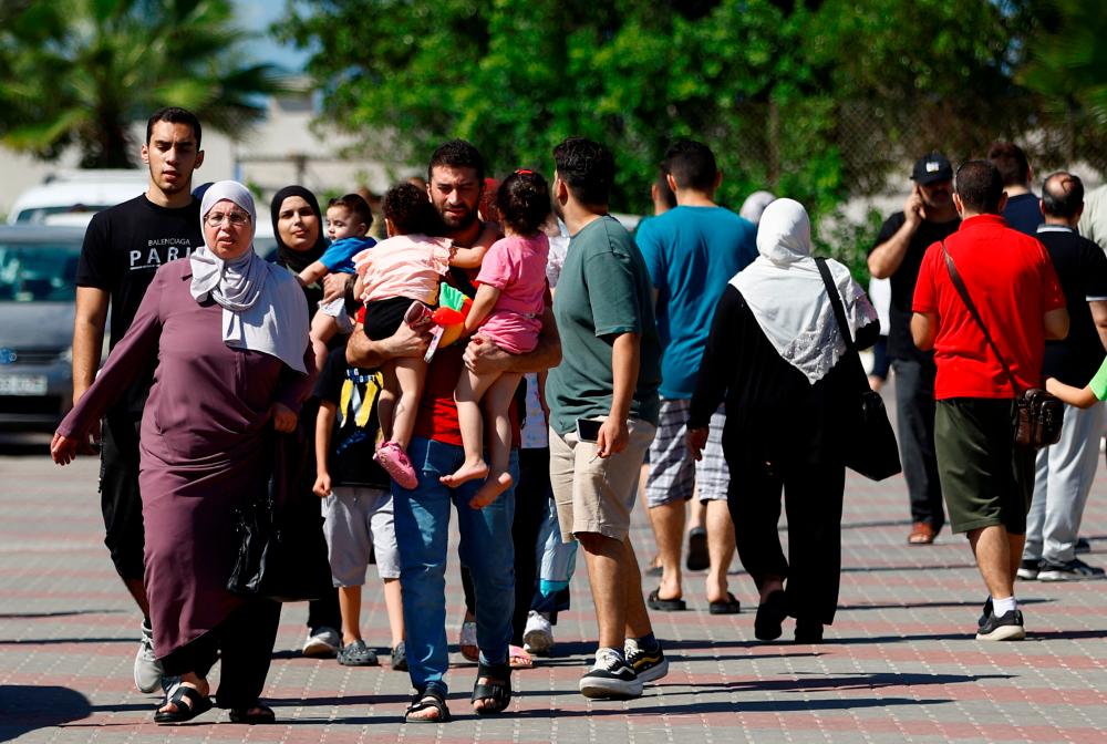 Families of staff of international organisations shelter at a United Nations center after UNRWA said it relocated its central operations centre to the south of Gaza Strip after Israel’s call for more than 1 million civilians in northern Gaza to move south within 24 hours, amid the Israeli-Palestinian conflict, in Khan Younis in the southern Gaza Strip October 13, 2023/AFPPix