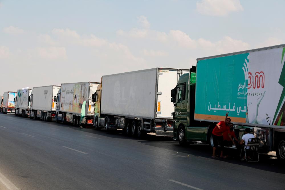 Trucks carrying humanitarian aid to Palestinians, wait on the desert road (Cairo - Ismailia) on their way to the Rafah border crossing to enter Gaza, amid the ongoing conflict between Israel and the Palestinian Islamist group Hamas, in Cairo, Egypt, October 14, 2023. REUTERSPIX