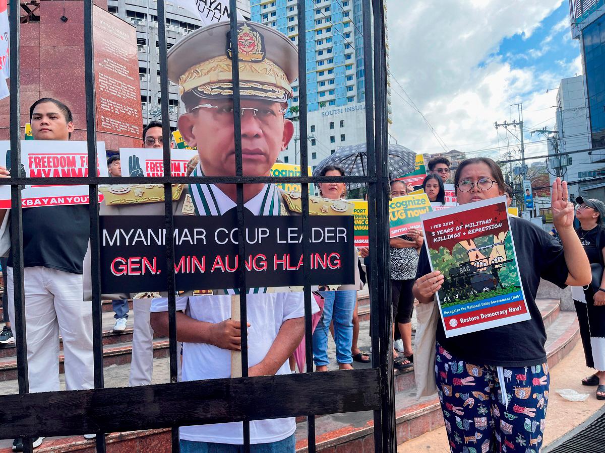 A Filipino activist holds a three finger salute while standing beside a cut out of Myanmar’s junta chief Min Aung Hlaing during a rally to mark the third year anniversary of Myanmar’s 2021 military coup. - Reuters pix