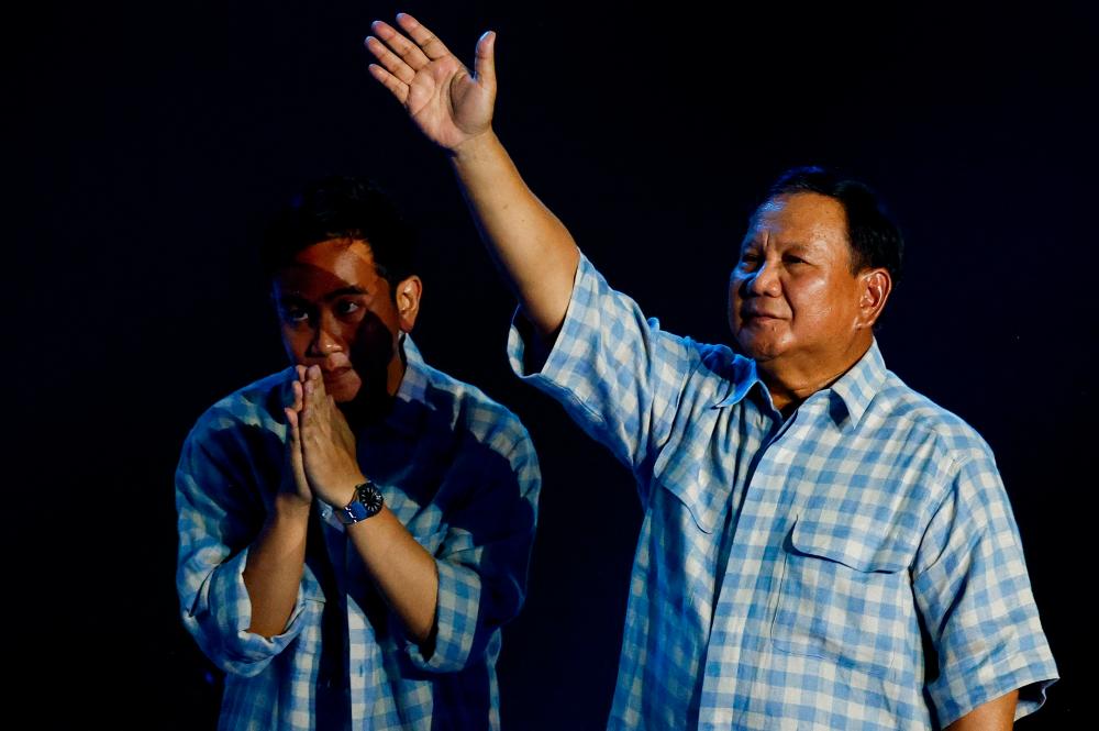 Presidential candidate Prabowo Subianto gestures to his supporters next to Vice President candidate Gibran Rakabuming Raka as Subianto claims victory after unofficial vote counts during an event to watch the results of the general election in Jakarta, Indonesia, February 14, 2024. - REUTERSPIX