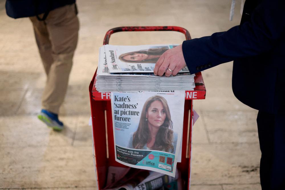 A commuter picks up a copy of the Evening Standard featuring a picture of Britain’s Catherine, Princess of Wales, on the front page at subway station in London, Britain, March 12, 2024/REUTERSPix