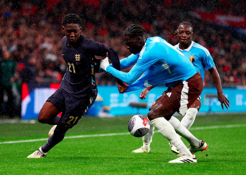 Football - International Friendly - England v Belgium - Wembley Stadium, London, Britain - March 26, 2024England's Kobbie Mainoo in action with Belgium's Amadou Onana and Jeremy Doku - REUTERSPIX