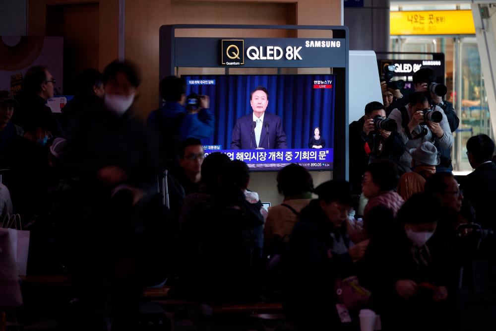 People watch a TV broadcasting a news report on South Korean President Yoon Suk Yeol’s speech on the doctors’ strike amid a prolonged standoff between the government and doctors’ groups over a plan to increase medical school admissions, in Seoul, South Korea, April 1, 2024/REUTERSPix