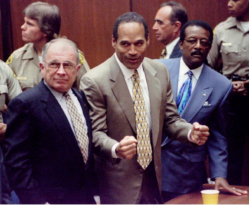 FILE PHOTO: Defendant O.J. Simpson (C) reacts after the court clerk announces that Simpson was found not guilty of the murders of Nicole Simpson and Ronald Goldman, as defense attorneys F. Lee Bailey (L) and Johnnie Cochran, Jr. (R) look on in a Los Angeles courtroom, October 3, 1995. - REUTERSPIX