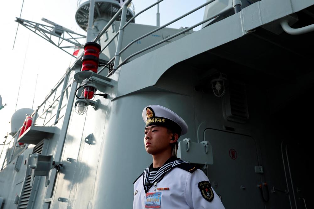 A member of the Chinese People's Liberation Army (PLA) Navy stands guard on the Shijiazhuang, a Type 051C guided-missile destroyer, as the Navy opens warships for public viewing to mark its upcoming 75th founding anniversary, at the port in Qingdao, Shandong province, China April 20, 2024. - REUTERSPIX