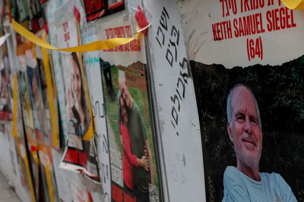A view of a banner depicting Keith Siegel, who is a dual U.S. citizen seized during the October 7 attack on Israel and taken hostage into Gaza, amid the ongoing conflict between Israel and Hamas, is seen with other images of hostages in Tel Aviv, Israel, April 28, 2024/REUTERSPix